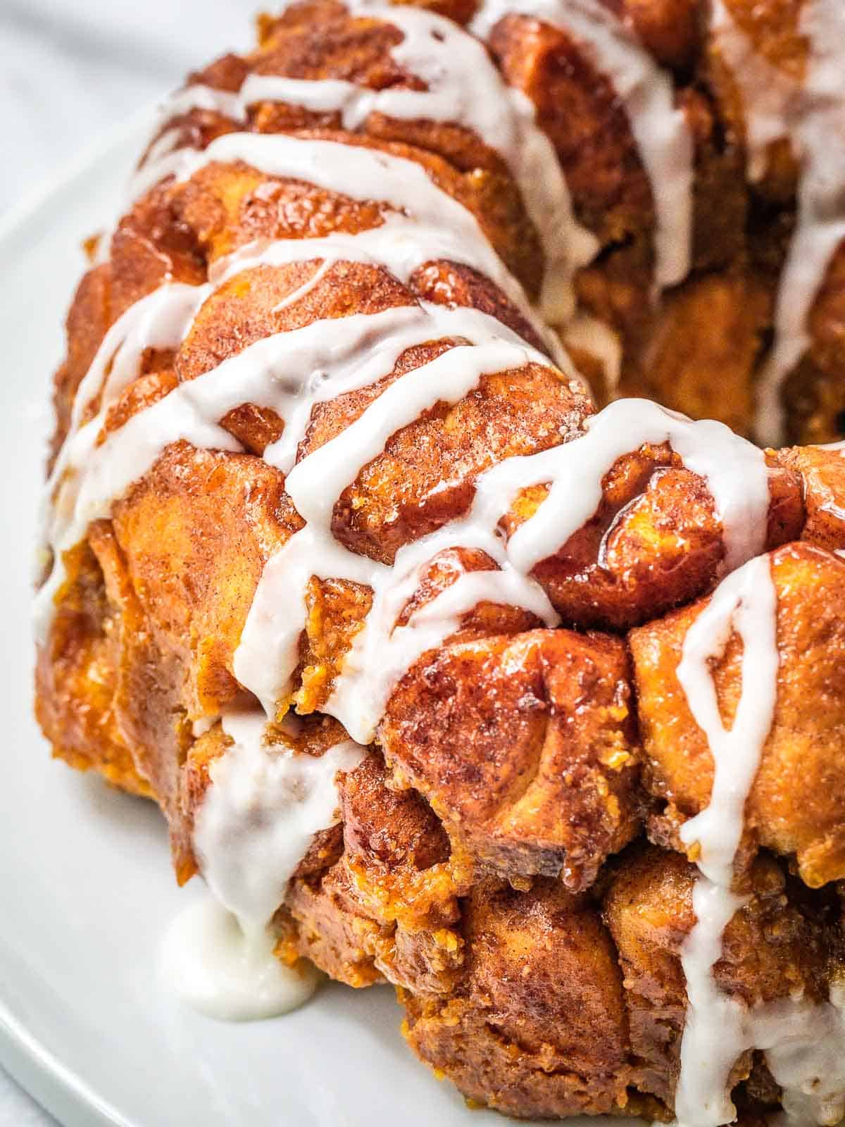 Pumpkin monkey bread with glaze running over the sides.