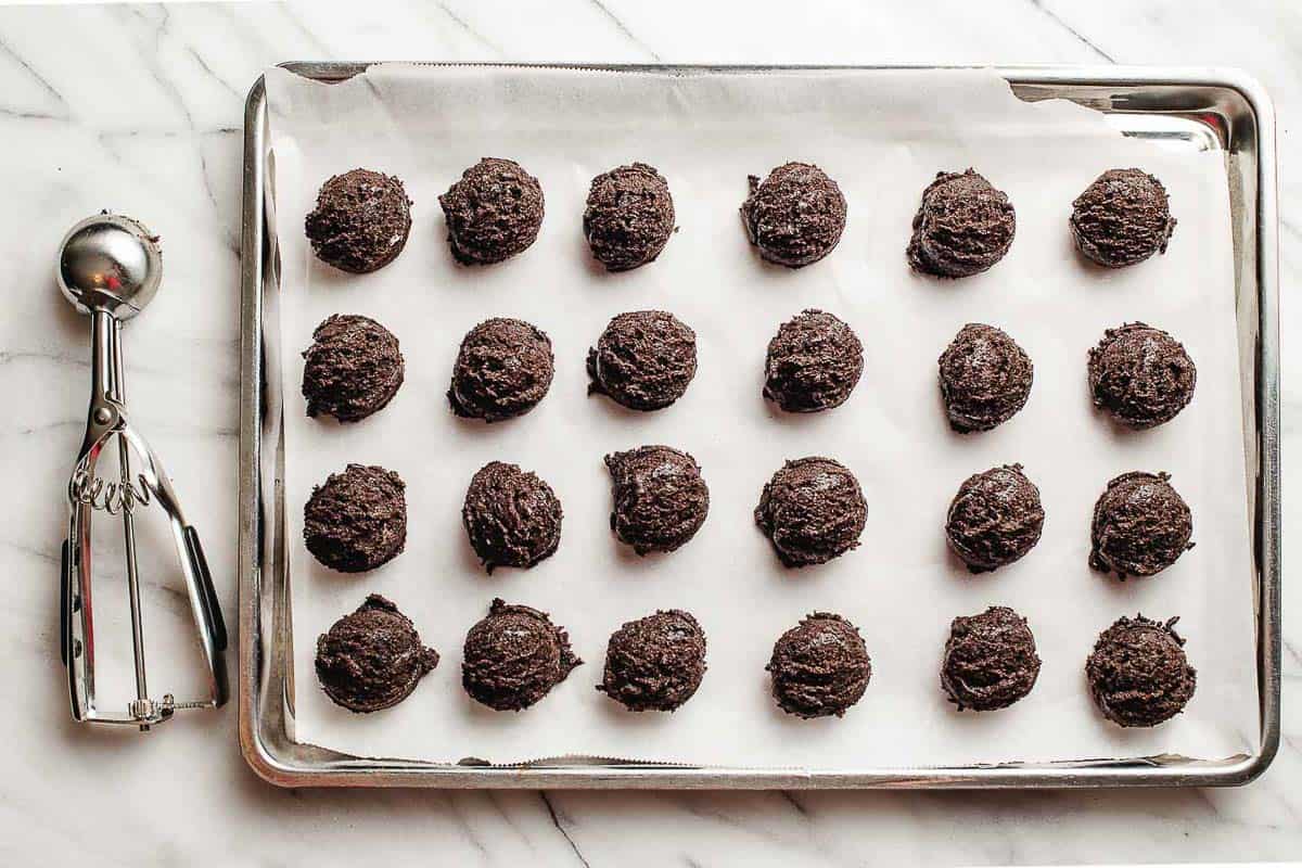 Scoops of oreo ball mixture on a baking sheet.