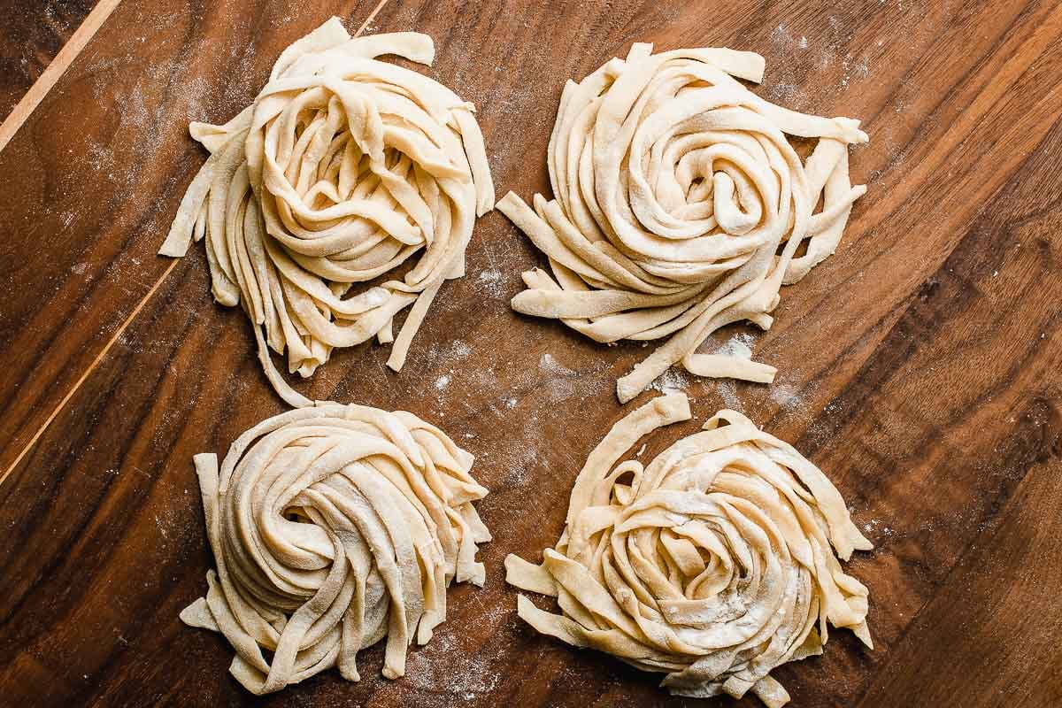 Nests of sourdough pastas on a cutting board.