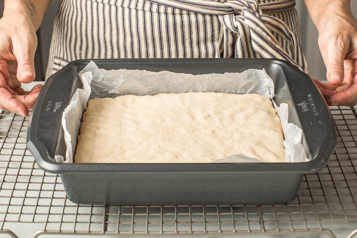 A baking tin with sourdough sugar cookie bars cooling.