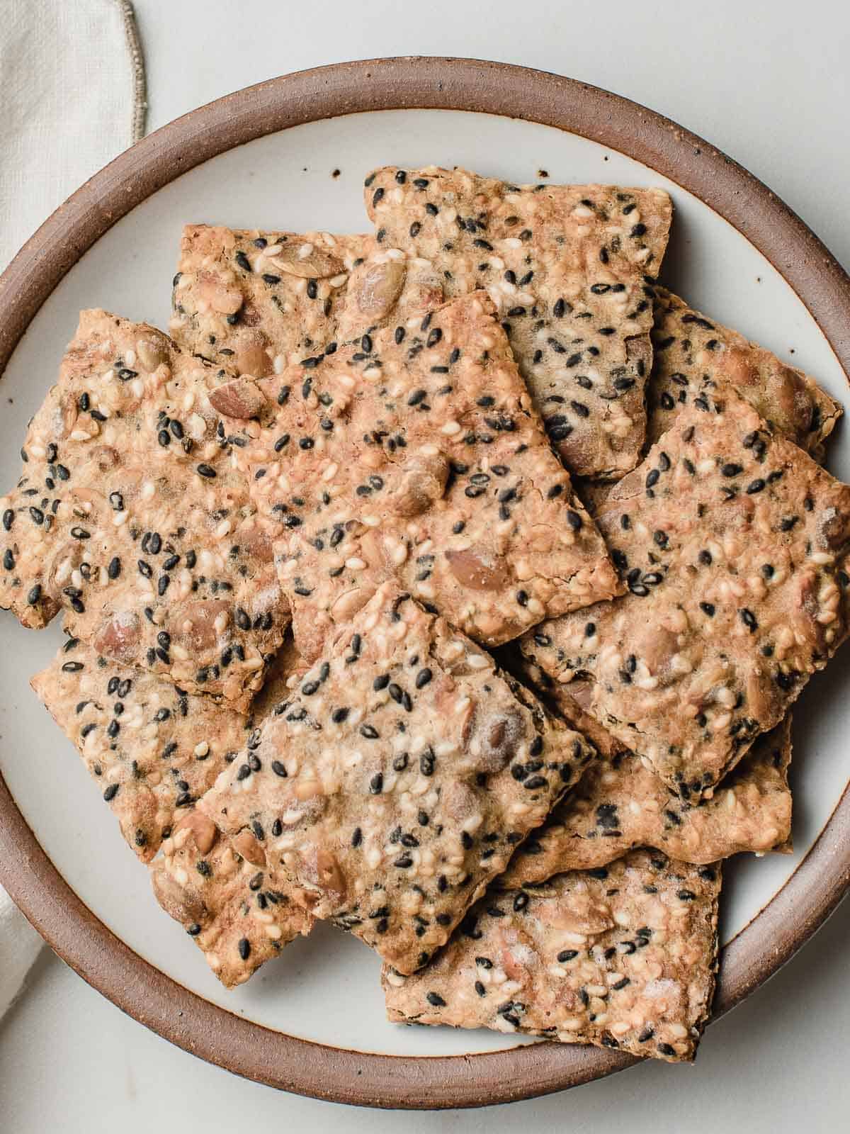 Baked sourdough seed crackers on a plate.