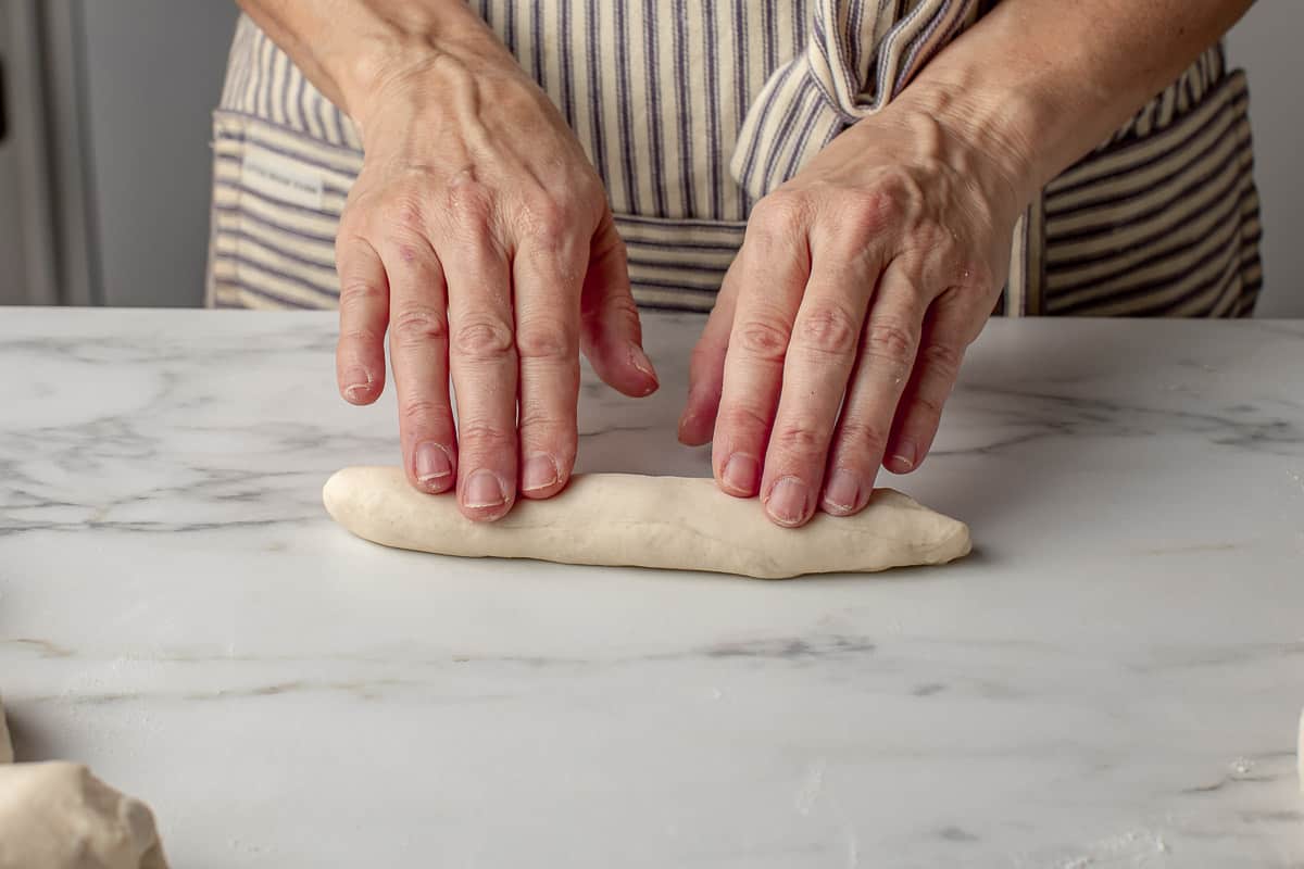 A woman shaping the breadstick dough.
