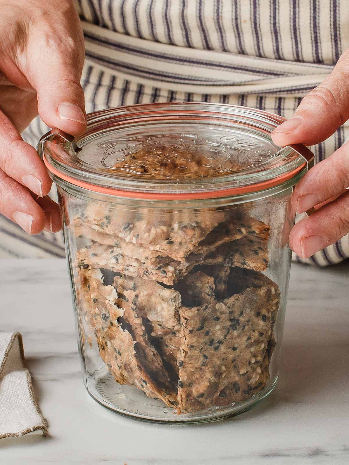 Sourdough seed crackers stored in a glass jar.