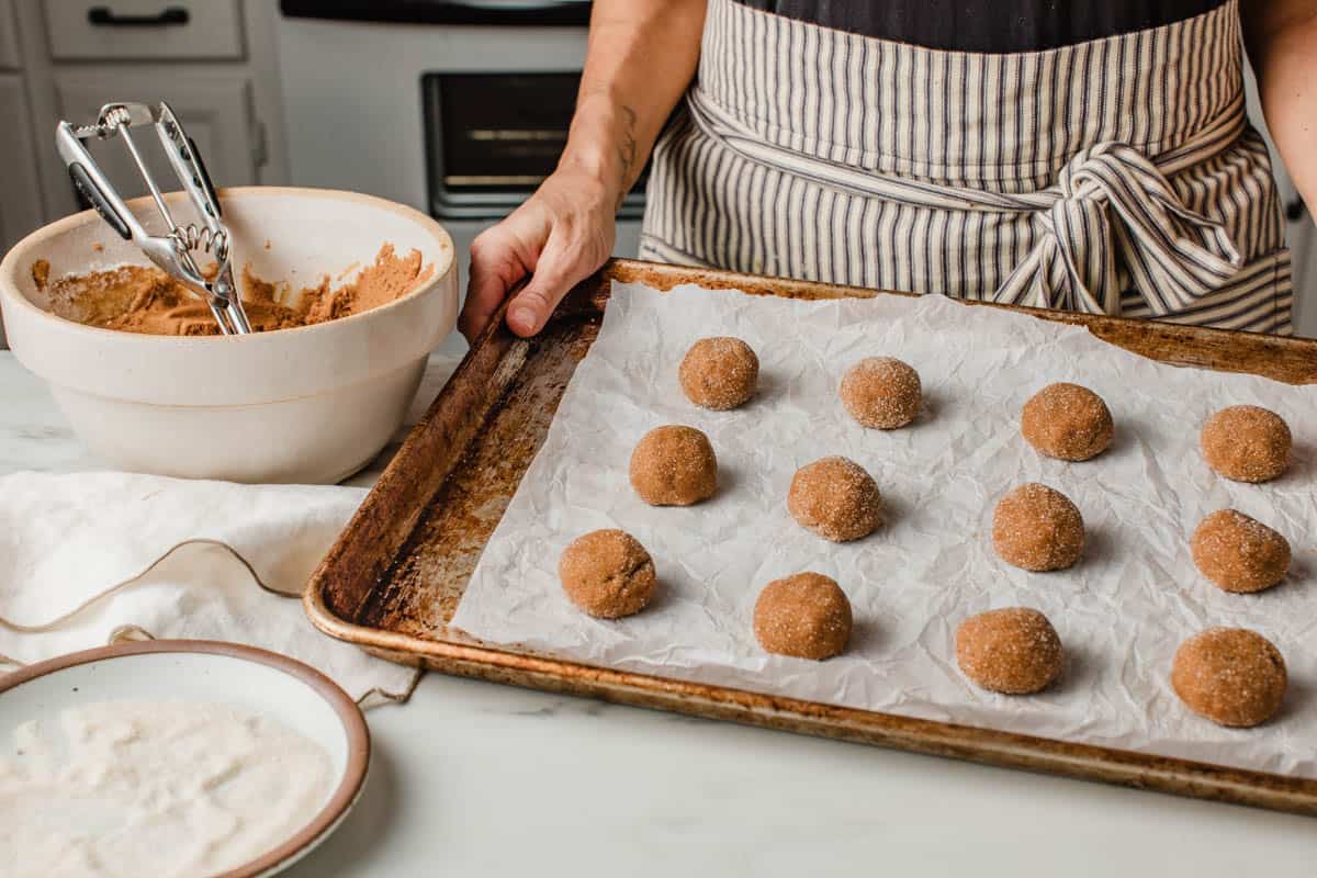 Portioning sourdough ginger molasses cookie dough onto a baking sheet.