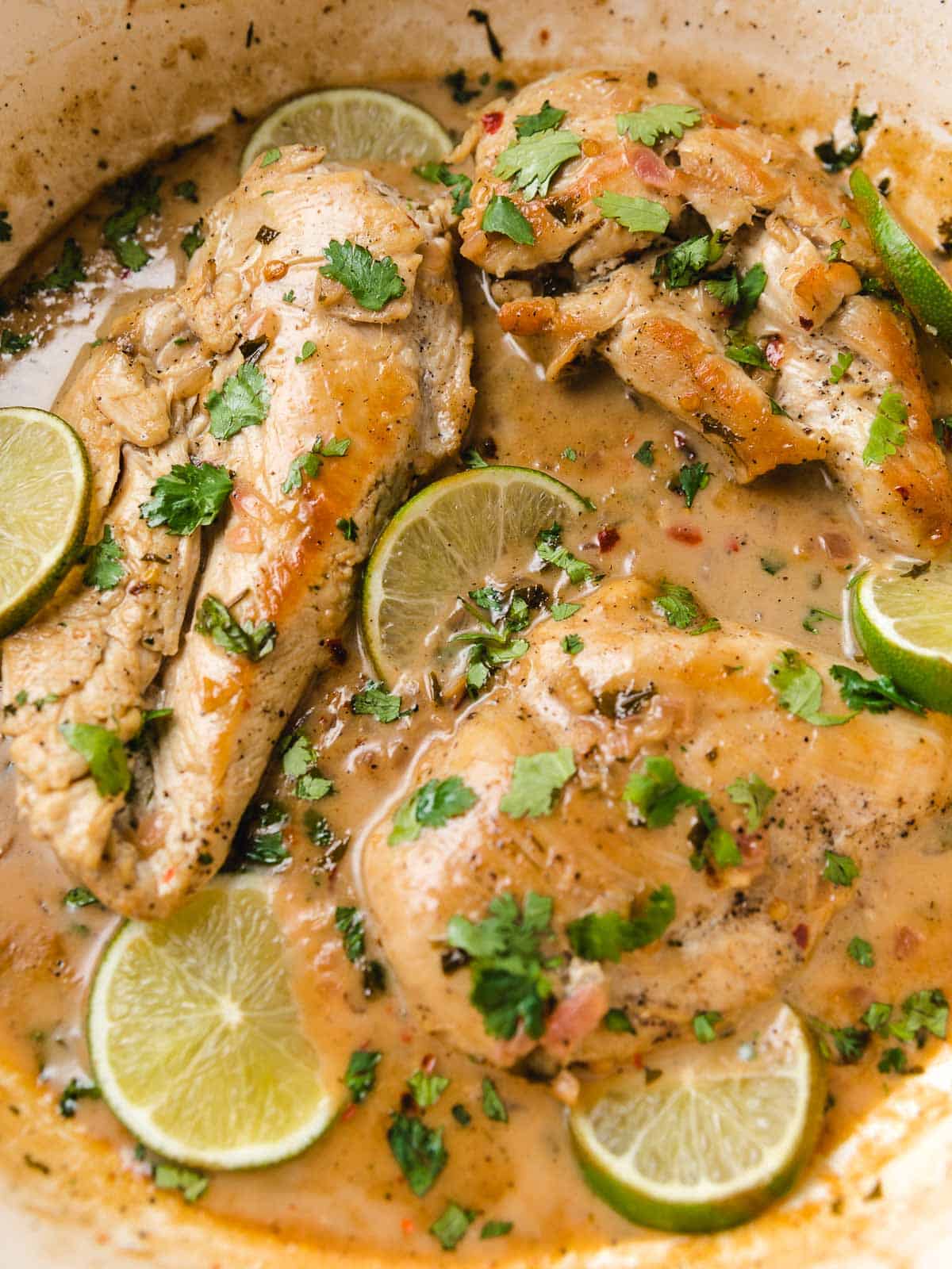 A closeup photo of coconut lime chicken in a skillet.