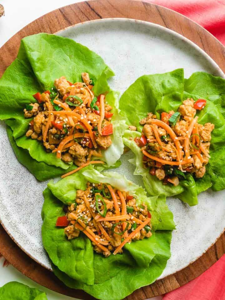 Asian chicken lettuce wraps on a white plate.