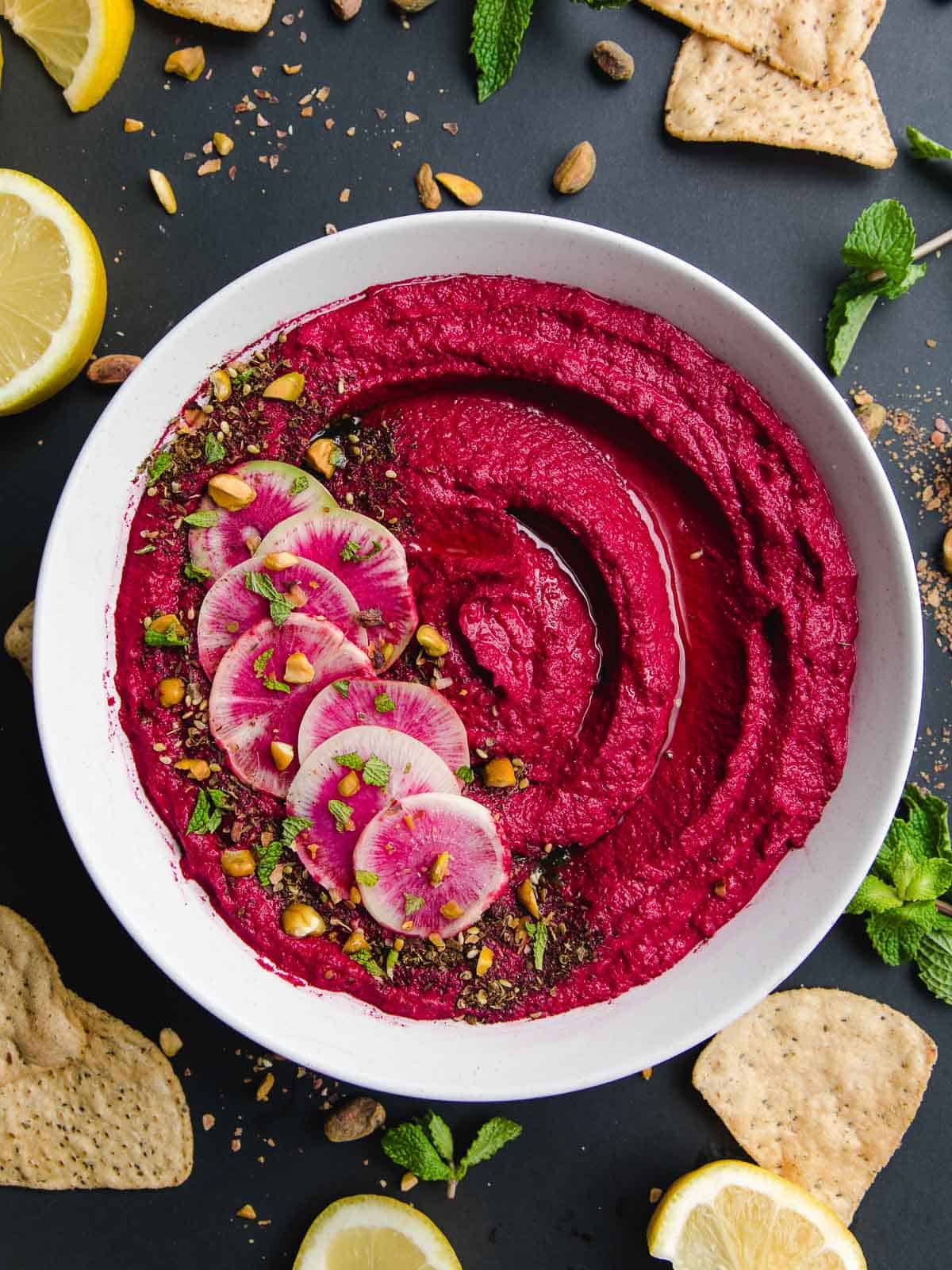 Roasted beet hummus in a bowl with crackers.