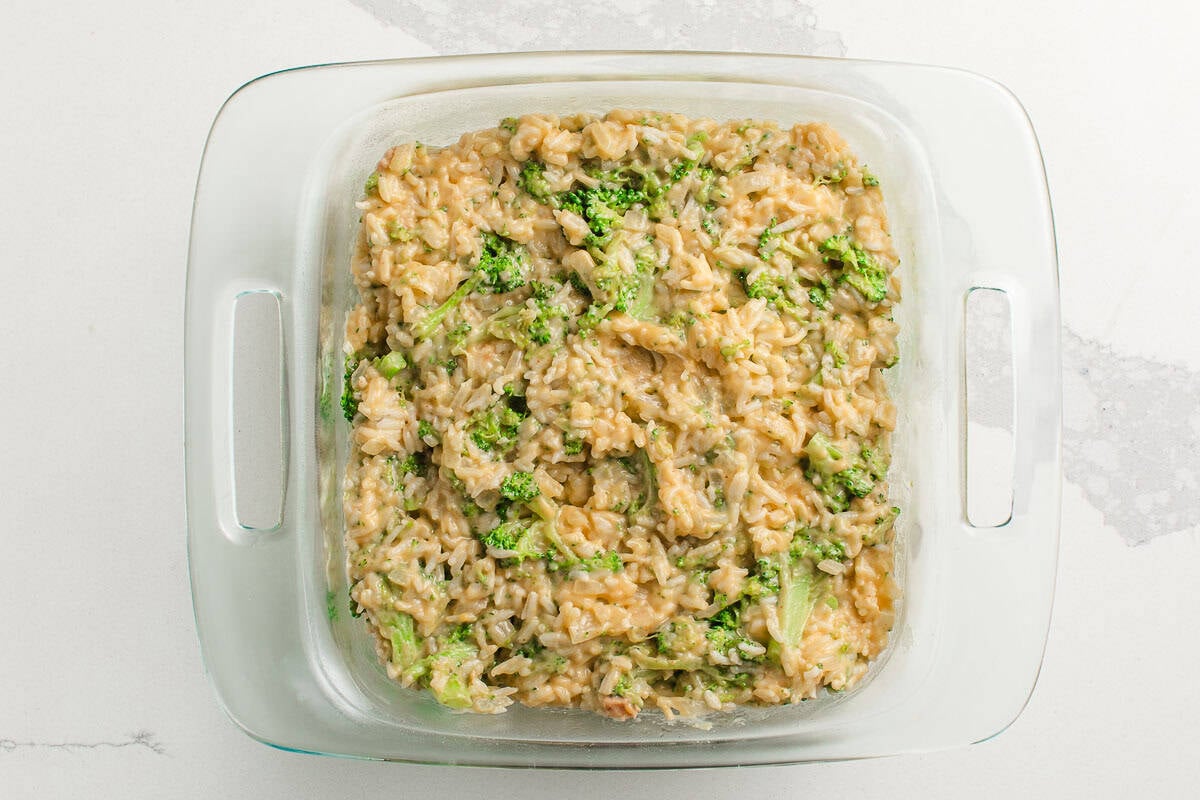 Broccoli rice casserole ingredients in a casserole dish.