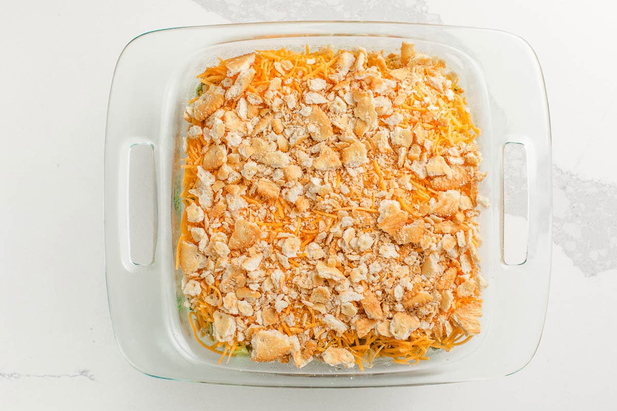 Broccoli rice casserole topped with cheese and crackers.