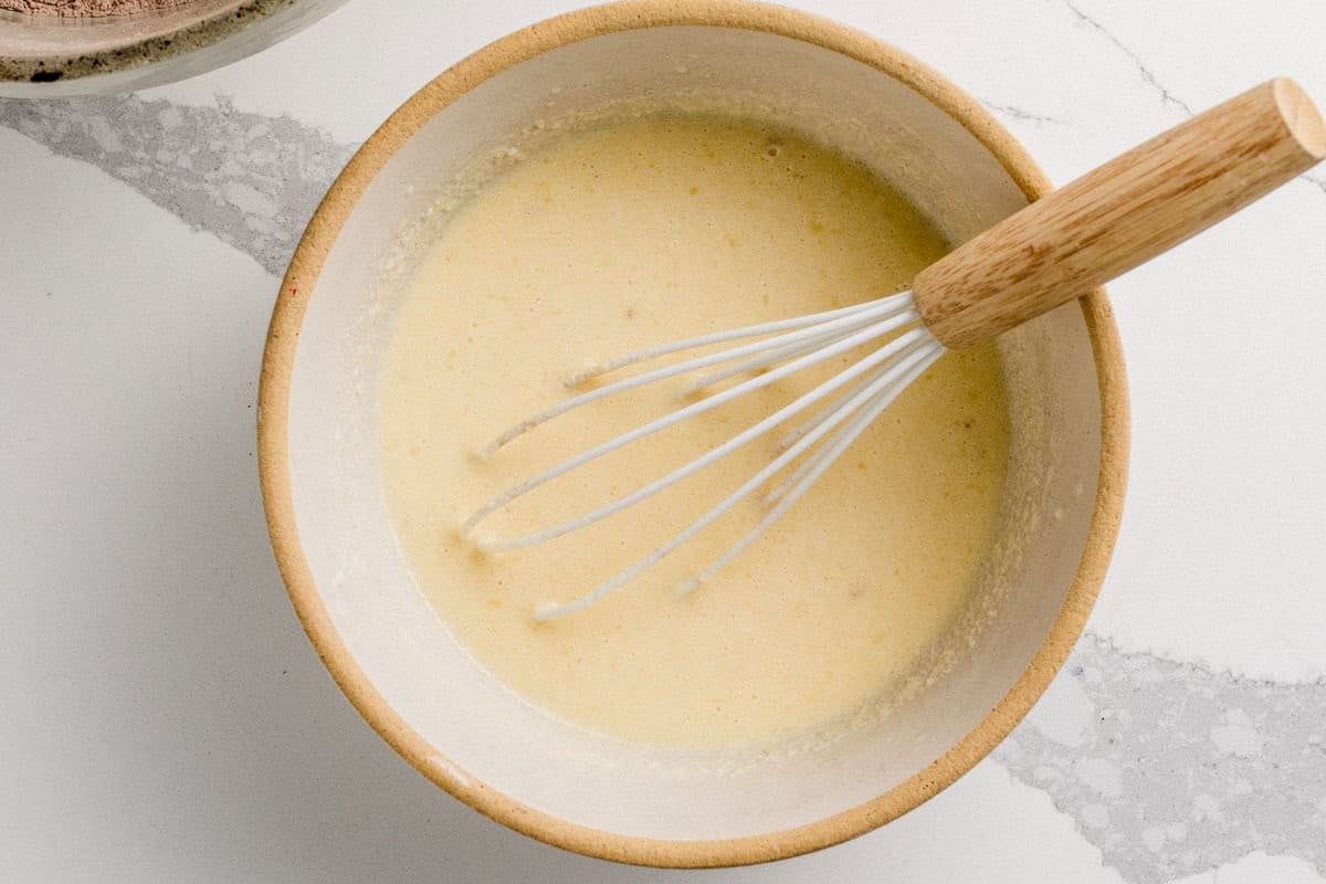Wet ingredients in a bowl for chocolate sourdough waffles.