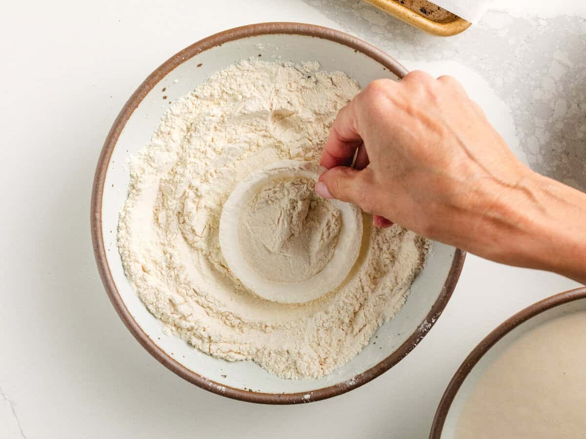 Dipping an onion ring in flour.