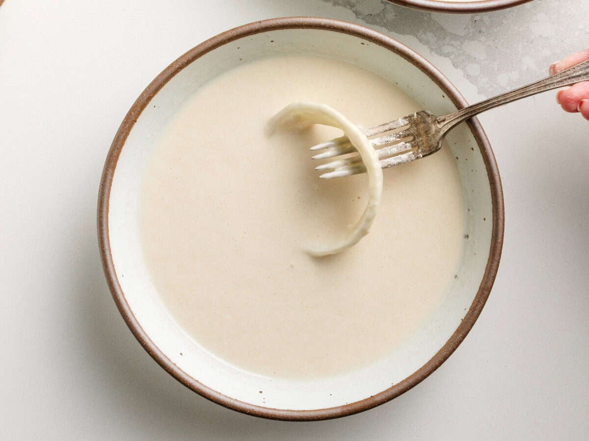 Dipping an onion ring in sourdough starter discard.