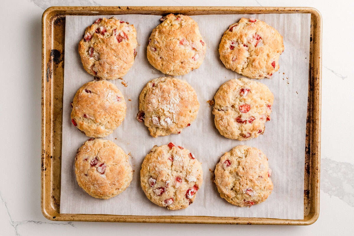 Baked sourdough strawberry biscuits on a baking sheet.